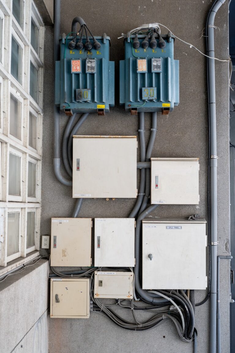 Electrical boxes and transformers mounted on a wall.
