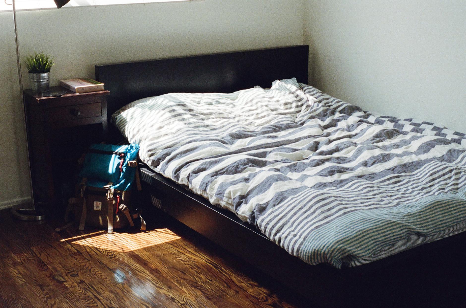 Bett rutscht auf Laminat – minimalistisches Schlafzimmer mit gestreifter Bettwäsche