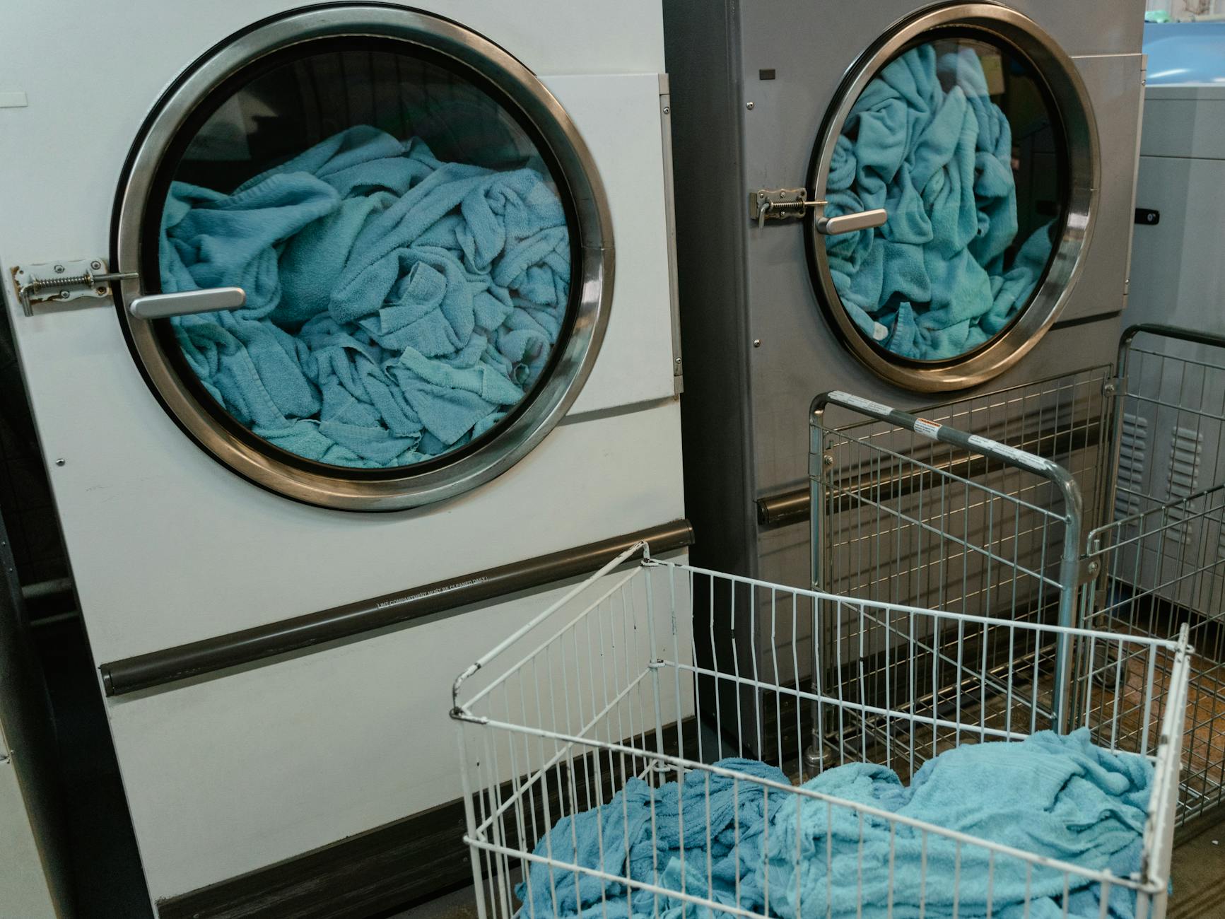 Waschmaschinentrommel schlägt – Industrie-Waschmaschinen mit blauen Handtüchern