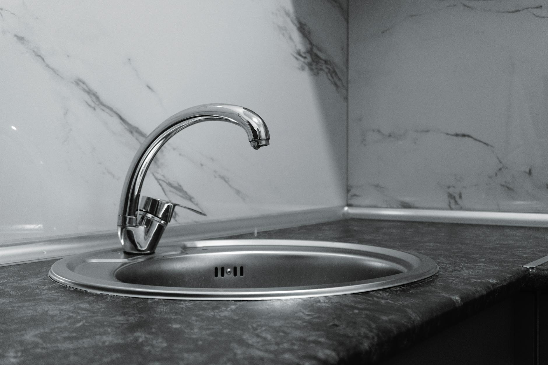 Wasserhahn aufdrehen – Edelstahl-Armatur in einer modernen Küche