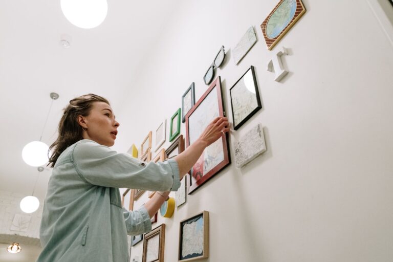 Bilder gerade aufhängen – Person hängt einen Rahmen an die Wand