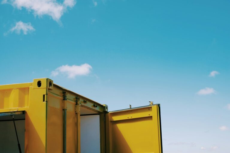 Lagercontainer auf dem Grundstück: Aufstellung, Fundament und Genehmigung yellow and white building under blue sky during daytime