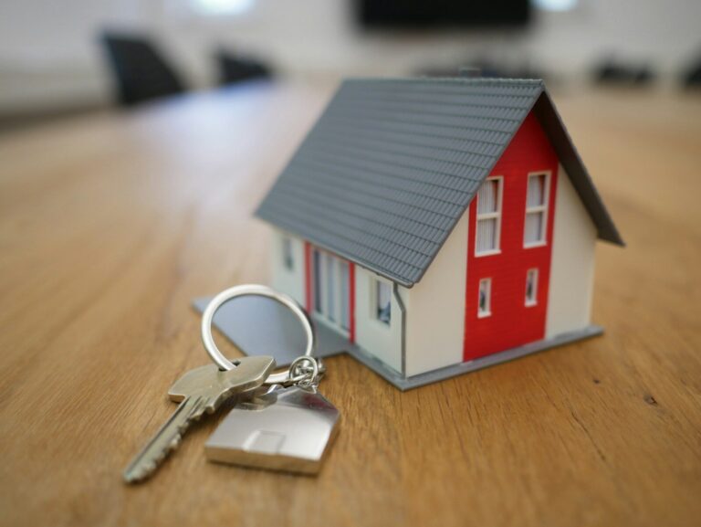 Nachhaltige Baustoffe als Werttreiber bei Finanzierung und Wiederverkauf white and red wooden house miniature on brown table