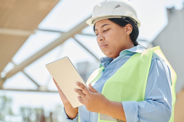 Planmanagement – Bauleiter prüft digitalen Bauplan auf dem Tablet auf der Baustelle